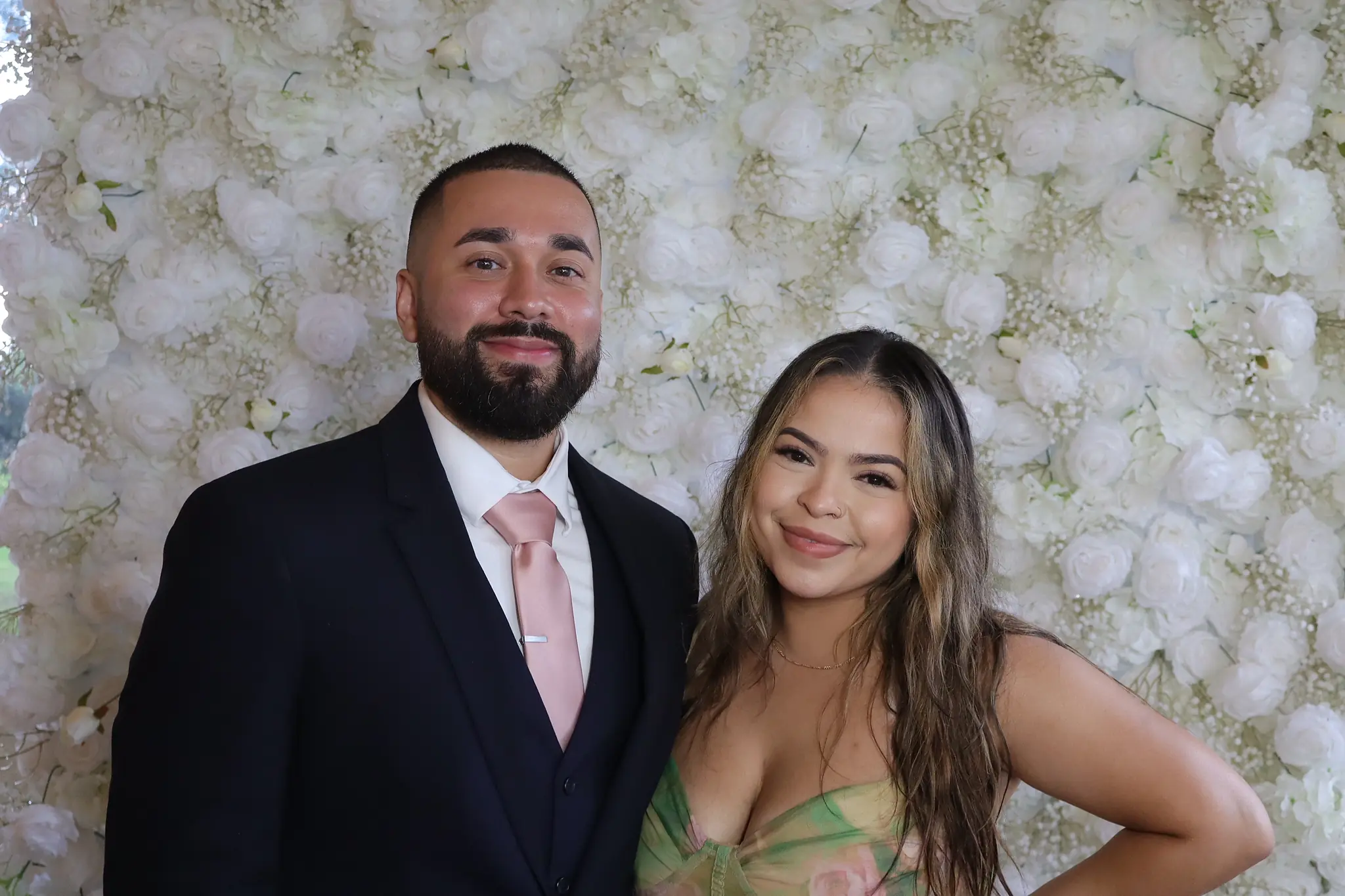Two Caretto wedding guests photographed against the floral wall by Images & Creations