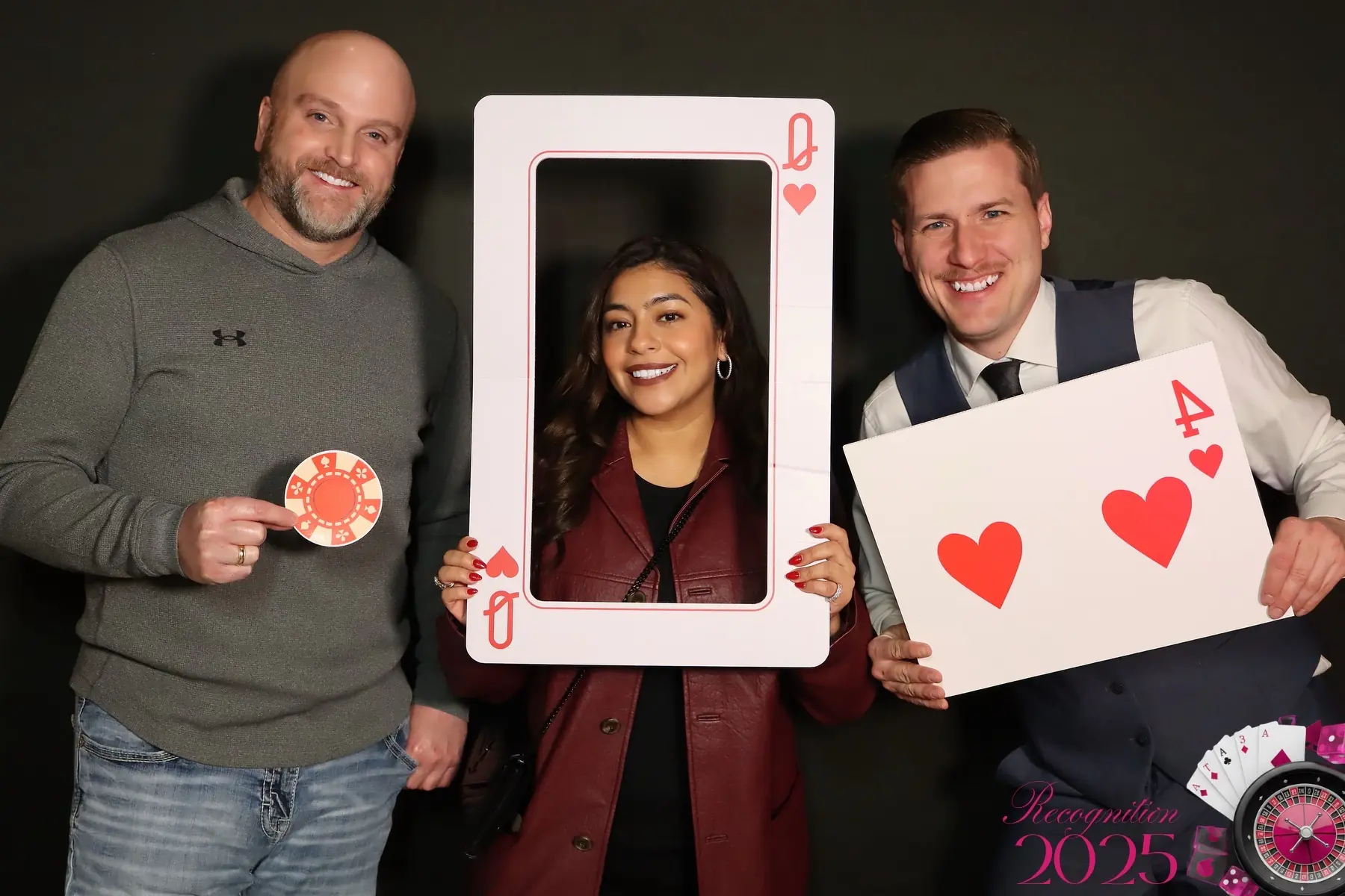 Three corporate-event guests posing with casino props
