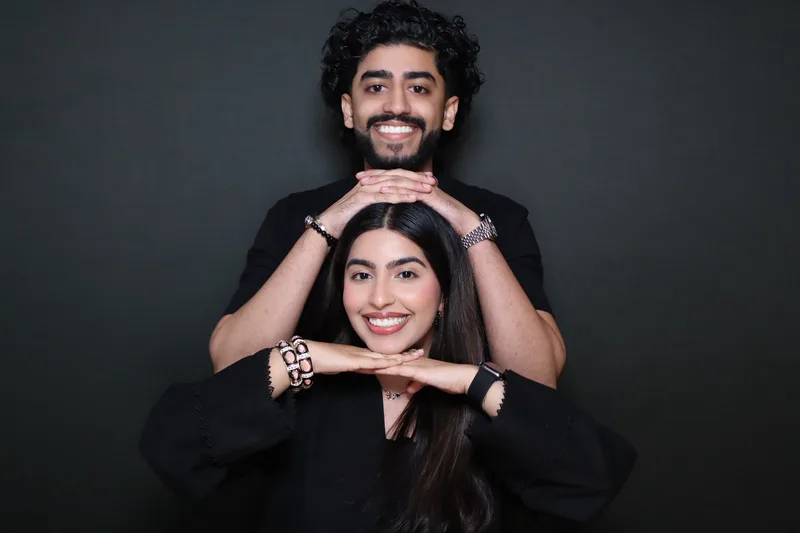 Two party guests laughing and posing for a photo